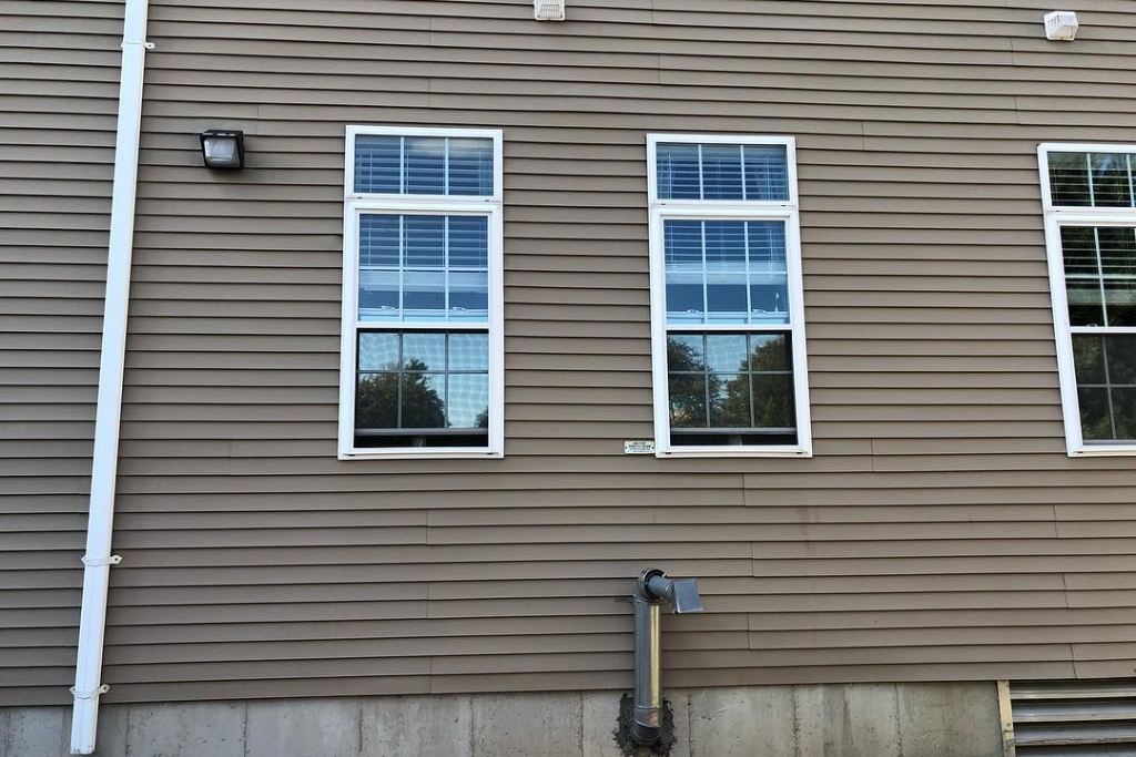 Exterior view of a Massachusetts home with reflective window film applied for privacy and UV protection, showing how home window tinting benefits include increased daytime privacy and modern curb appeal.