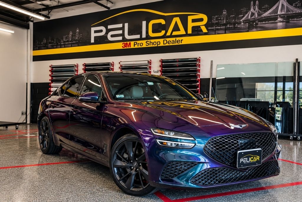 Color-shifting purple and blue Genesis sedan displayed inside Pelicar's 3M Pro Shop Dealer facility in Malden, MA.